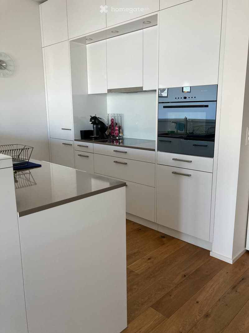 modern kitchen with white cabinets, stainless steel appliances, and a granite countertop