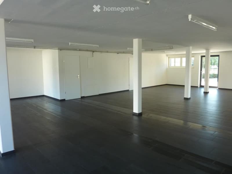 Completely empty room with bare walls and dark wooden floor. No furniture or equipment.