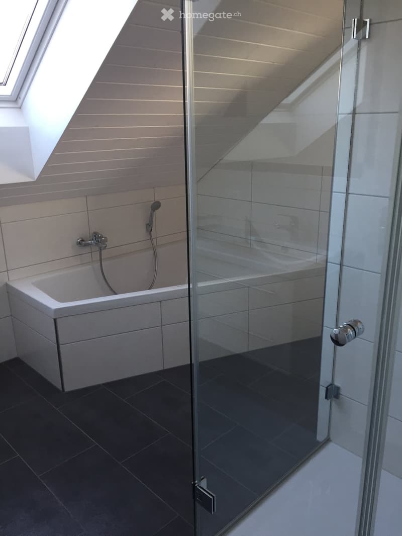 white modern bathroom with glass shower, bathtub, sink, shower head and wall tiles