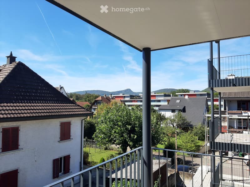 balcony with metal railing, view of surrounding houses, greenery, mountains in the distance