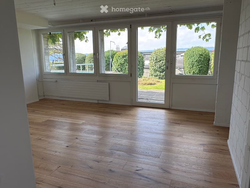 Large windows, wooden floor, empty room