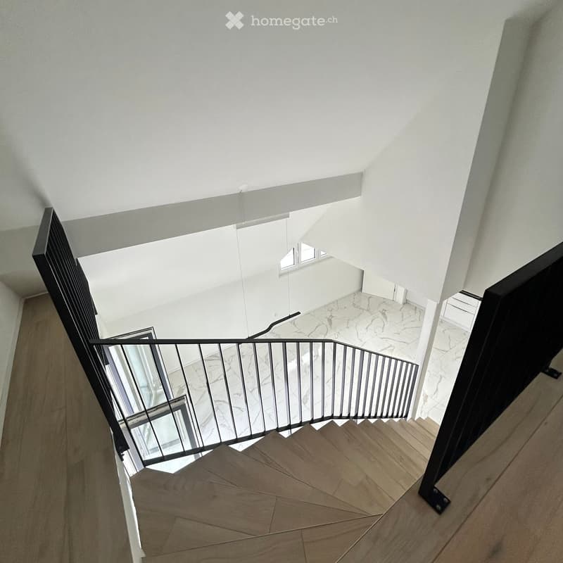Modern interior staircase with wooden steps, metal railing, and marble flooring, leading to an open, bright area with white walls and ceiling.