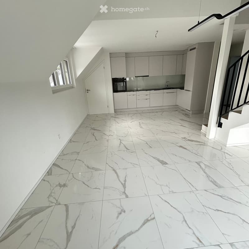 Empty room with white marble flooring, white walls, and a small window on the left side. The room has a modern, minimalist design with no visible furniture or appliances.