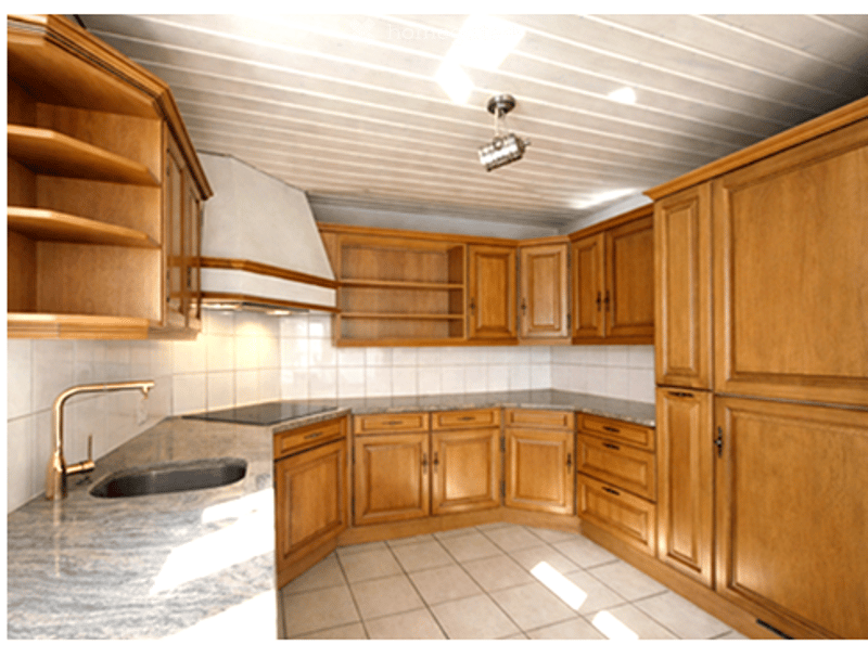 kitchen with wooden cabinets, granite countertop, sink, brass faucet, tiled floor, ceiling lamp
