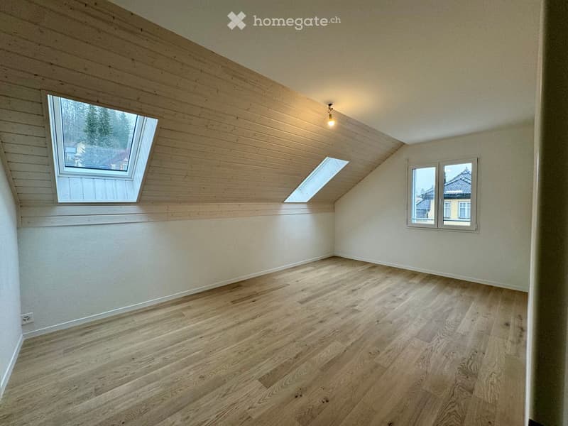 empty room, wooden floor, white walls, wooden ceiling, two skylights, small light fixture