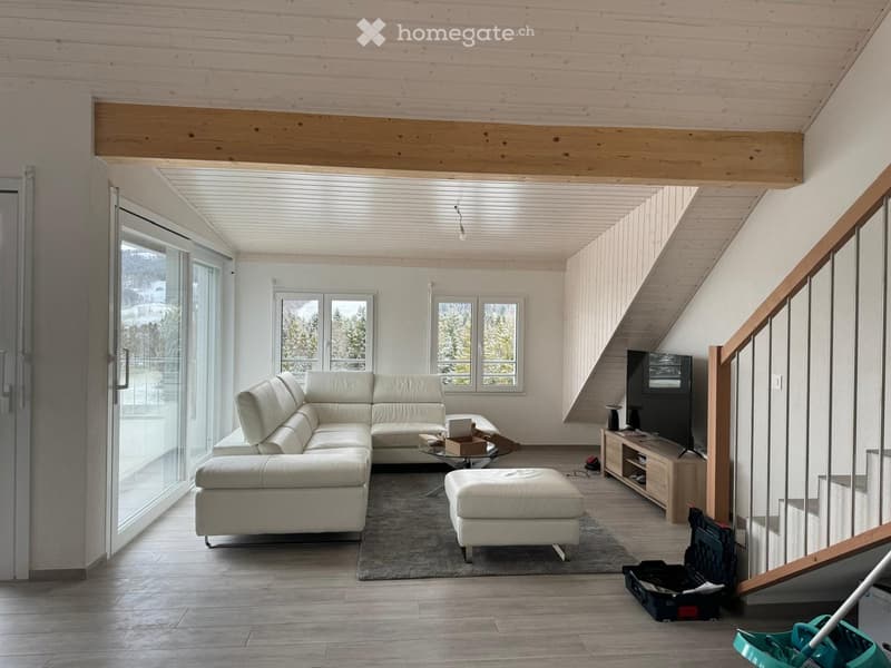 modern living room with white leather sofa, glass coffee table, TV, carpet, wooden floor, large windows, wooden beam