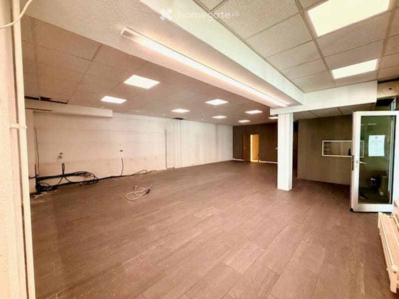 Empty room with wooden flooring, white walls, and recessed lighting. No furniture or equipment present.