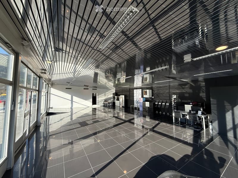 Modern, spacious lobby area with large windows, sleek furniture, and a polished tile floor.