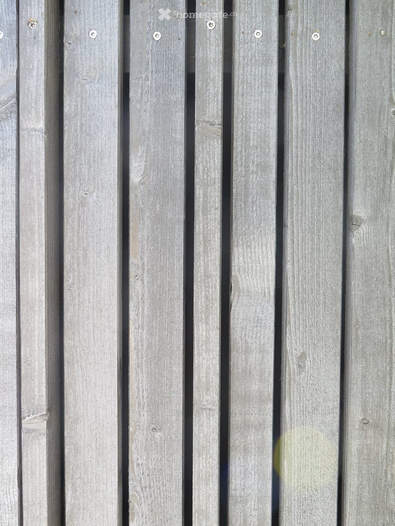 Close-up of weathered wooden planks with visible screws and natural grain patterns.