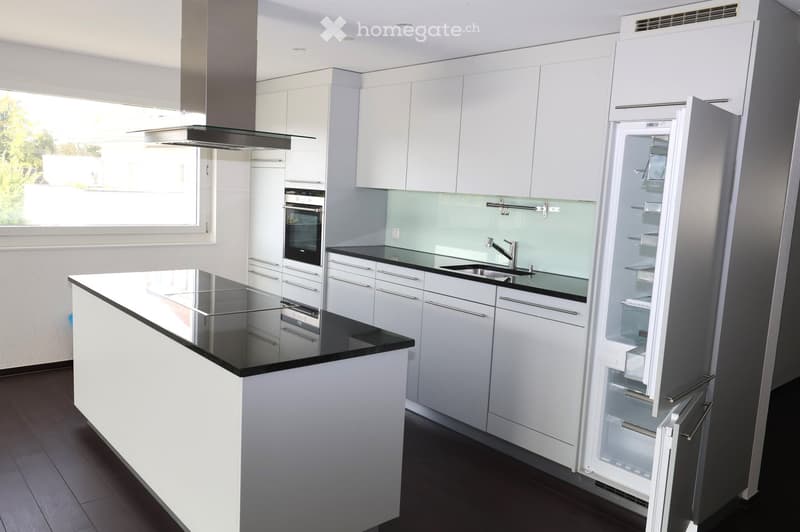 Modern kitchen with white cabinets, black granite countertops, stainless steel appliances, open refrigerator, and a window