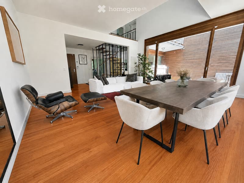 Modern living and dining area with hardwood flooring, white sofa, dining table with chairs, and decorative vases.
