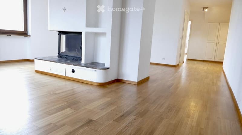 Empty room with light wooden flooring, white walls, and a built-in fireplace with a black insert. No furniture or personal items are present.