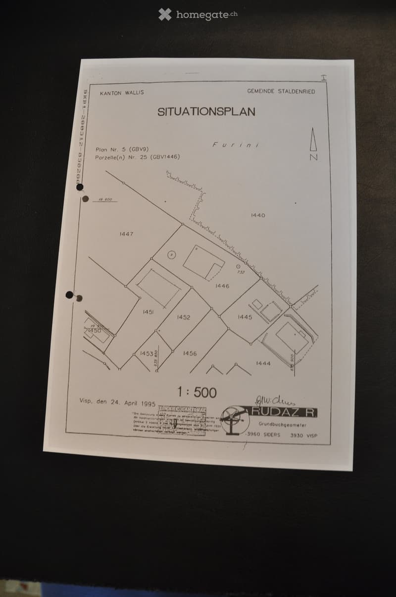 A detailed land plot plan showing various property boundaries, labeled sections, and measurements. Includes a north indicator and scale (1:500).