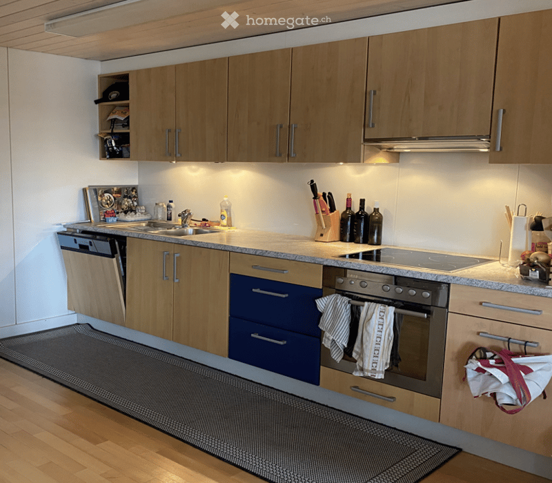 Modern kitchen with wooden cabinets, granite countertop, stainless steel appliances, and a dishwasher.