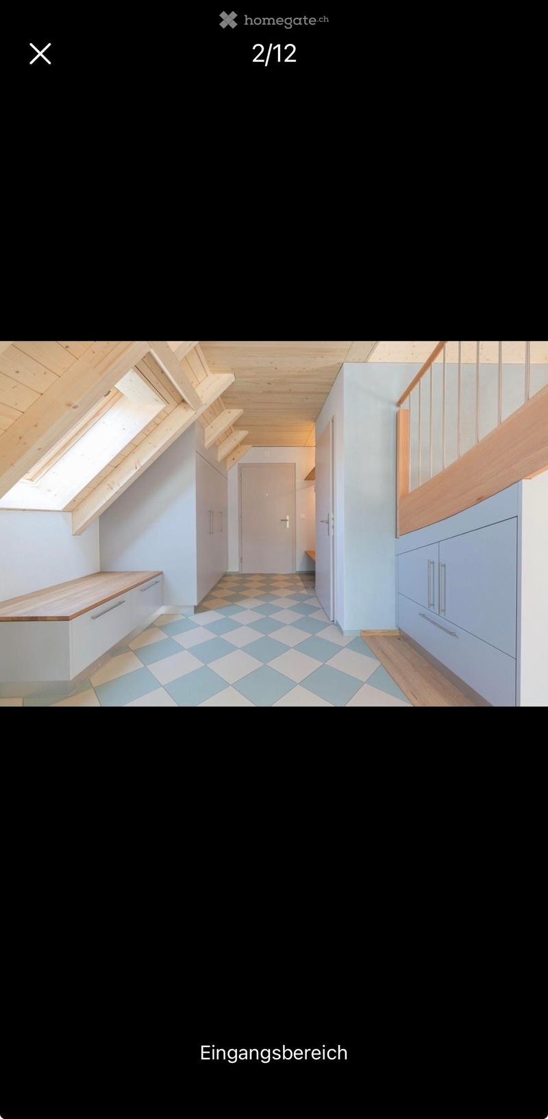 Bright, modern hallway with wooden ceiling beams, skylight windows, light blue walls, and a checkered floor. Features built-in storage cabinets and a small bench.