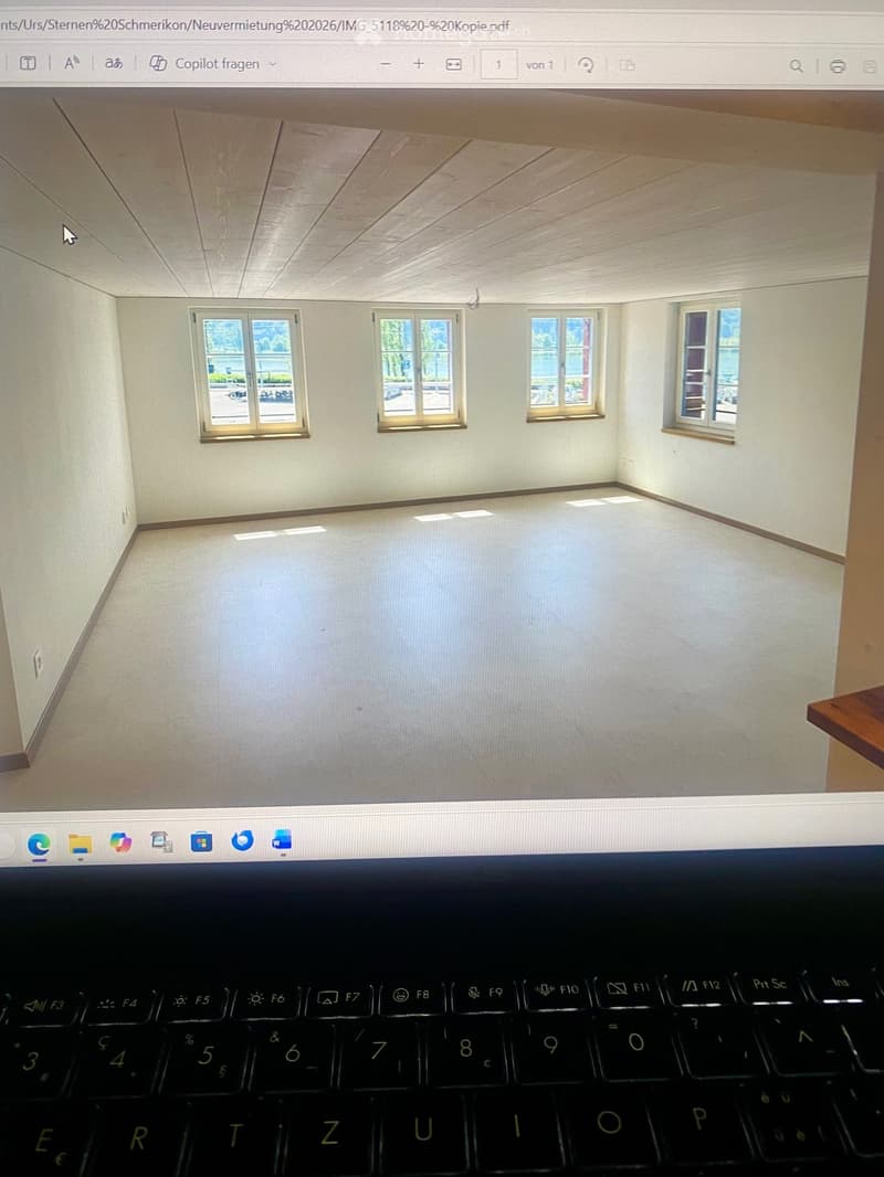 Empty room with four windows, light-colored walls, and a smooth floor. No furniture or equipment is present.