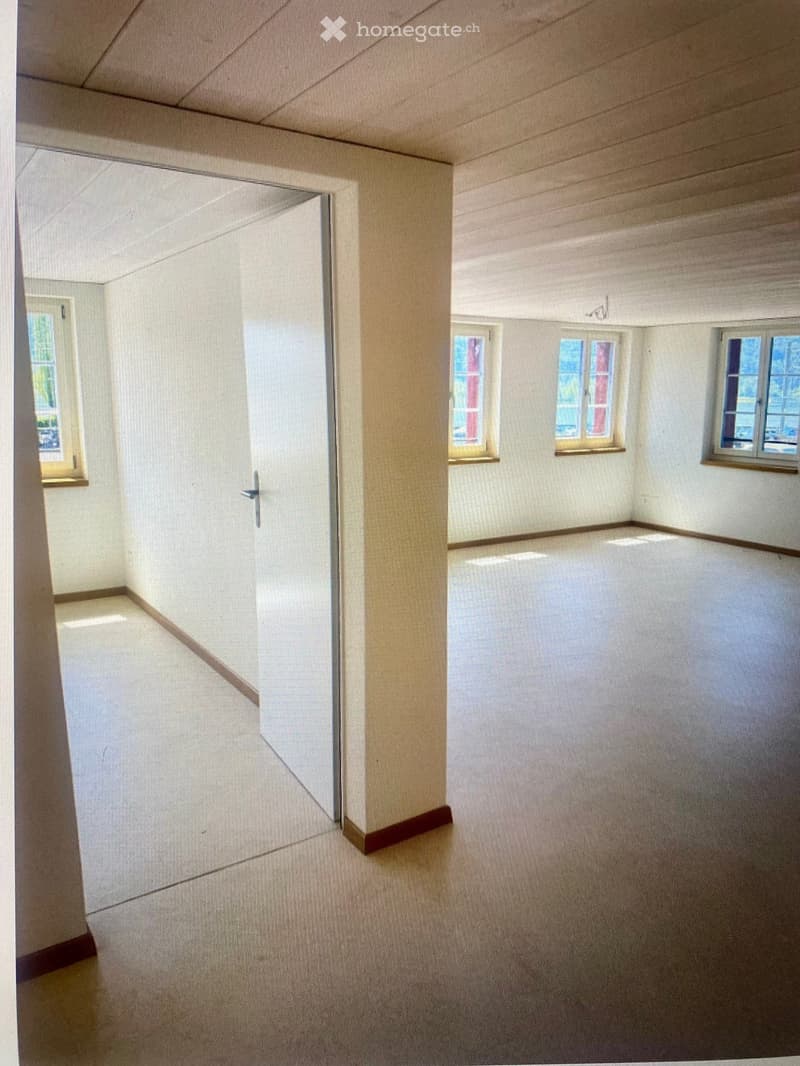 Empty room with white walls, wooden floor, and multiple windows allowing natural light. No furniture or equipment present.