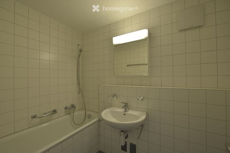 Bathroom with bathtub, sink, mirror, and shower head