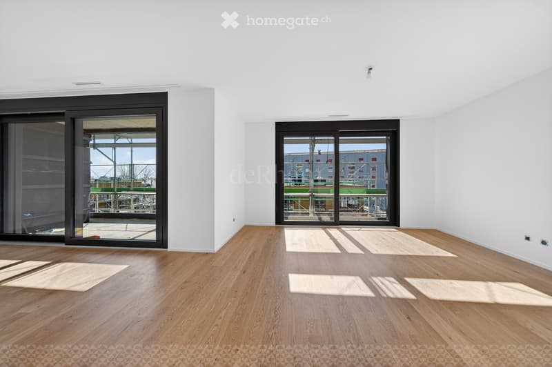 Empty room with wooden flooring, white walls, and large sliding glass doors leading to an outdoor area.