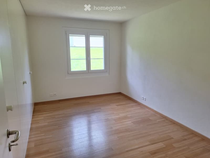 Empty room with wooden flooring, white walls, and a single window with white frame. No furniture or equipment present.