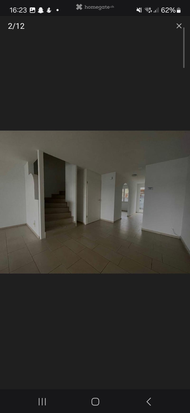 Empty hallway with tiled floor, white walls, and open doors leading to other rooms.