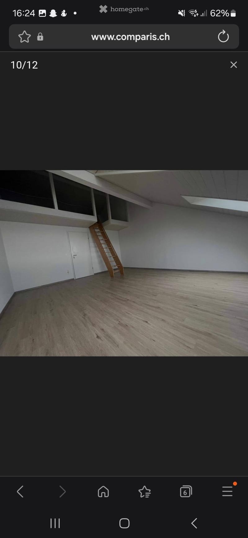 Empty room with wooden flooring, white walls, and a wooden ladder leading to an upper level.