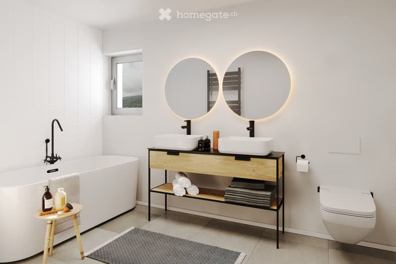Modern bathroom with a freestanding bathtub, double sink vanity with two round mirrors, a small wooden stool, and a toilet. The space features white tiles, a grey rug, and a window with a view.