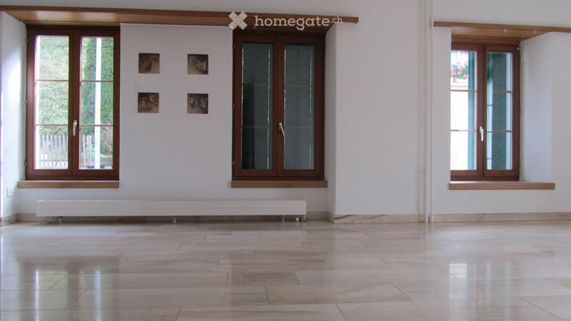 Unfurnished Room. Empty room with light-colored tiled floor, white walls, large windows with wooden frames, and a white radiator under one window. No furniture or equipment present.