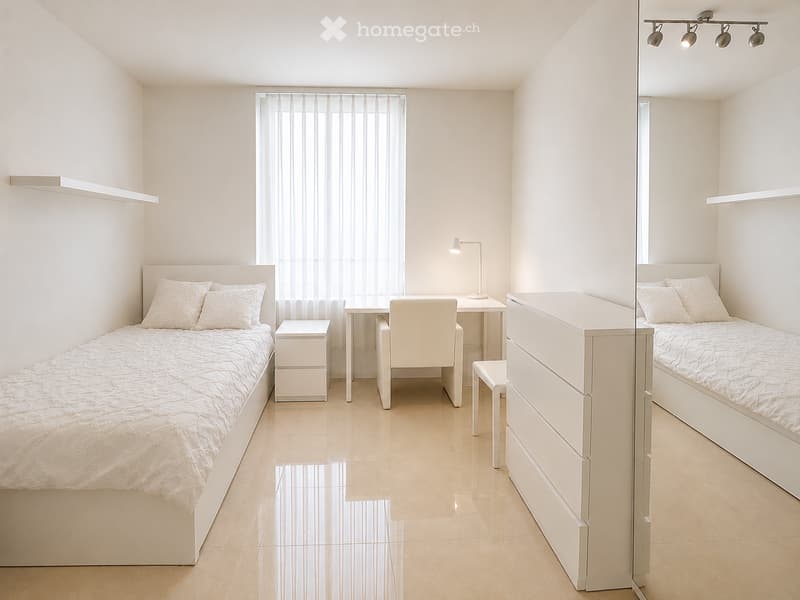 Modern, minimalist bedroom with two single beds, a small desk, and a chair. Light-colored bedding and furniture, large window with sheer curtains, and built-in shelving.