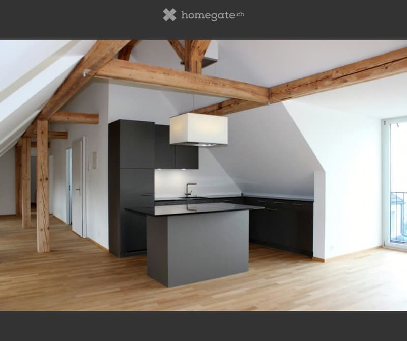 Modern kitchen with dark cabinets, a central island, and exposed wooden beams. Features a sleek pendant light and a minimalist design.
