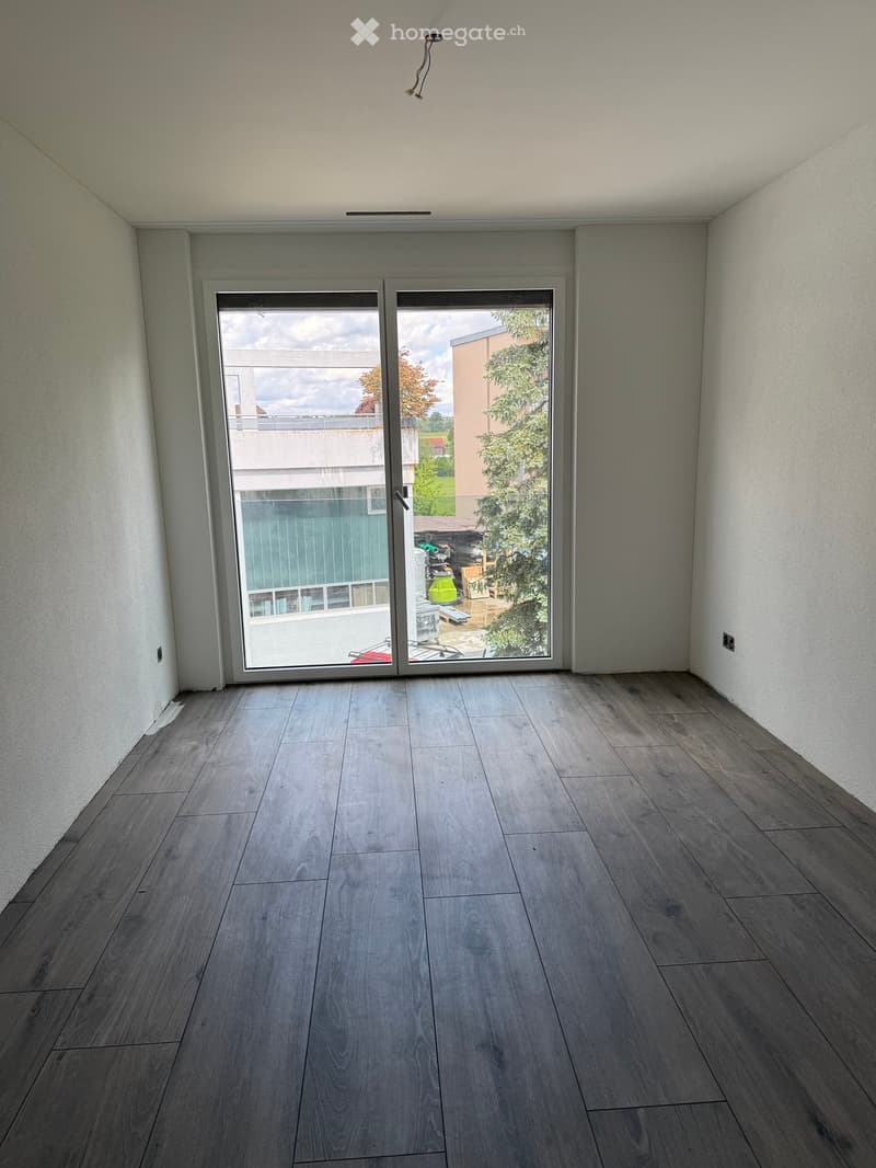 Unfurnished Room. Empty room with wooden flooring and large sliding glass doors leading to an outdoor area.