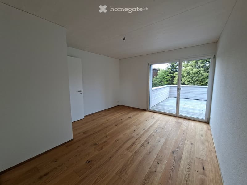 Unfurnished Room. Empty room with wooden flooring, white walls, and a large sliding glass door leading to a balcony or outdoor area.