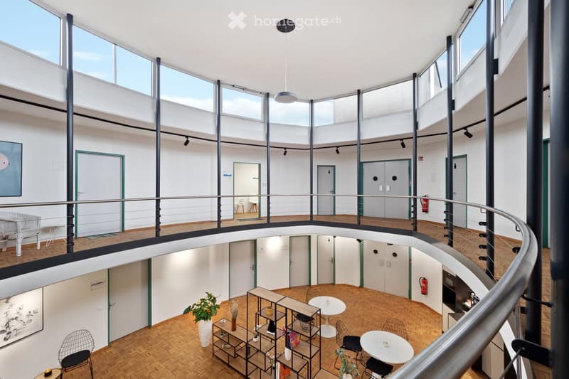 open space, wooden floor, white walls, round balcony, tables, chairs, shelves, plants