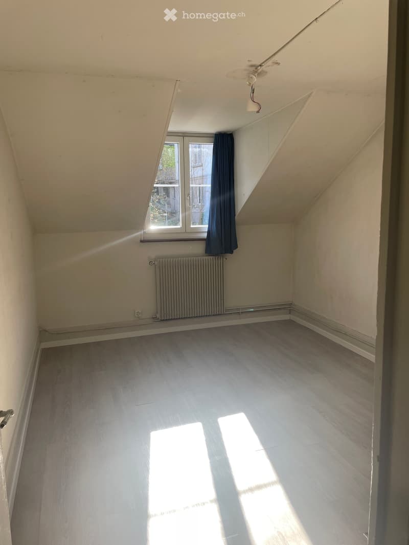 empty room, wooden floor, white walls, window with blue curtain, radiator