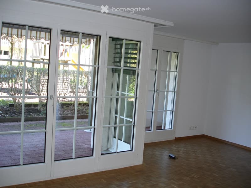 large glass doors, wooden floor, white walls, balcony