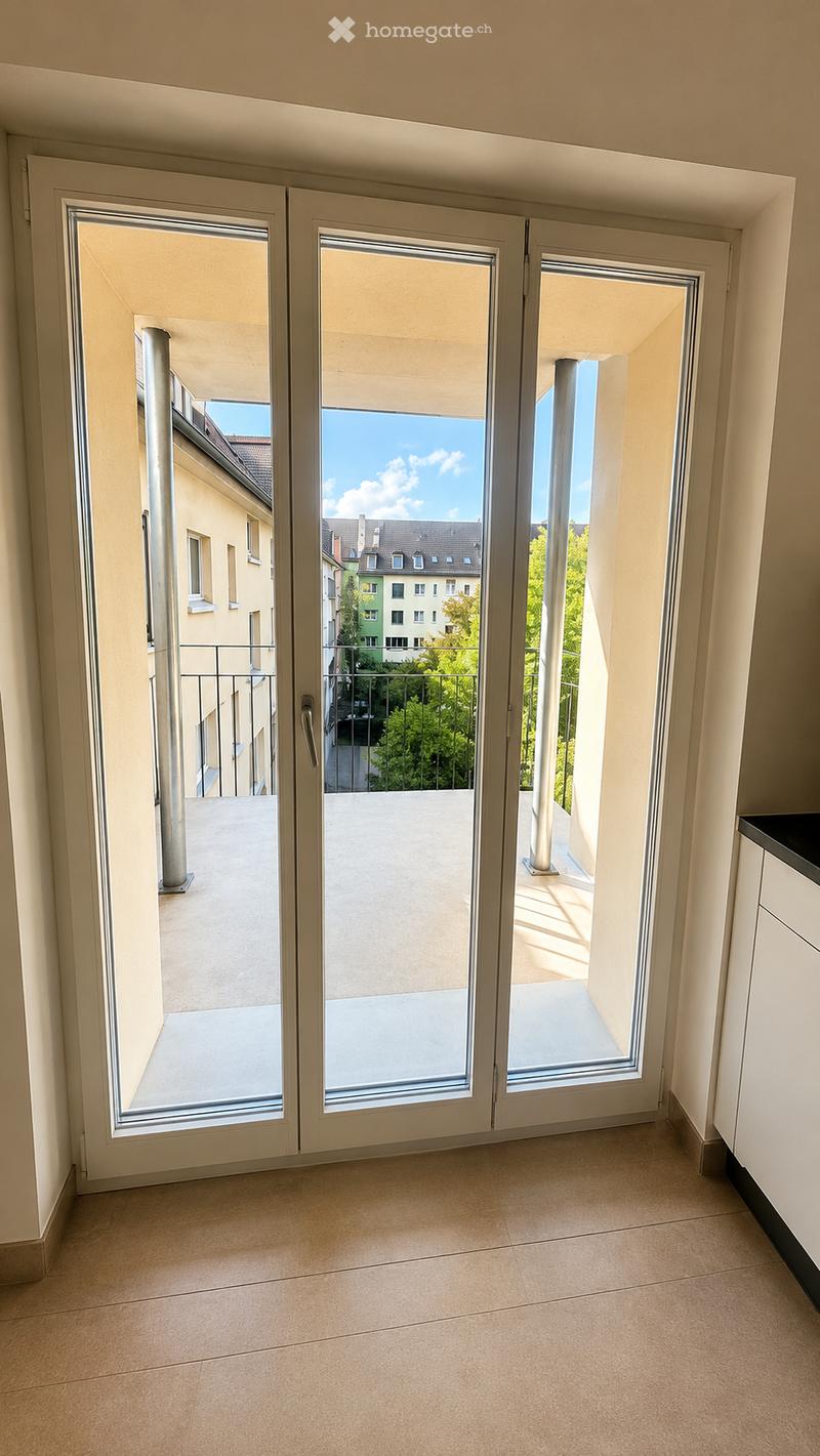 Empty room with tiled floor, large sliding glass doors leading to a balcony with a view of the city and surrounding buildings.