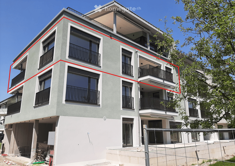Modern multi-story apartment building with grey facade, large windows, and balconies.