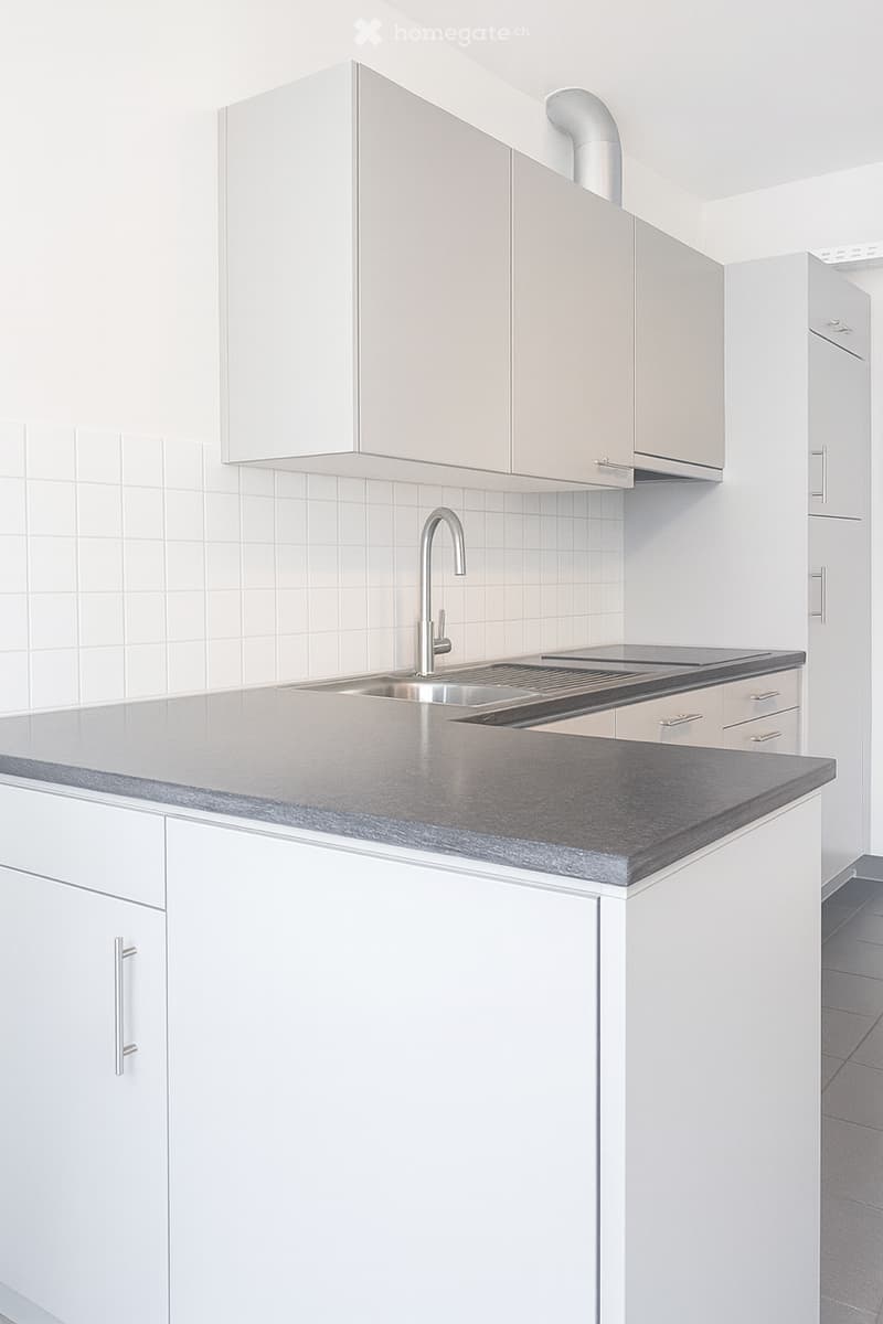 white kitchen with modern appliances and tile flooring