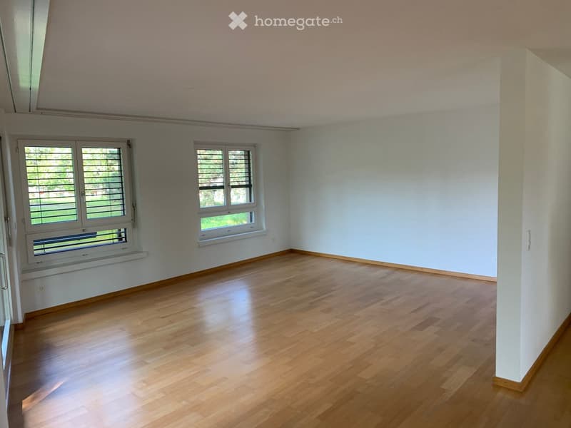 Empty room with wooden flooring, white walls, and two windows with blinds. No furniture or equipment present.