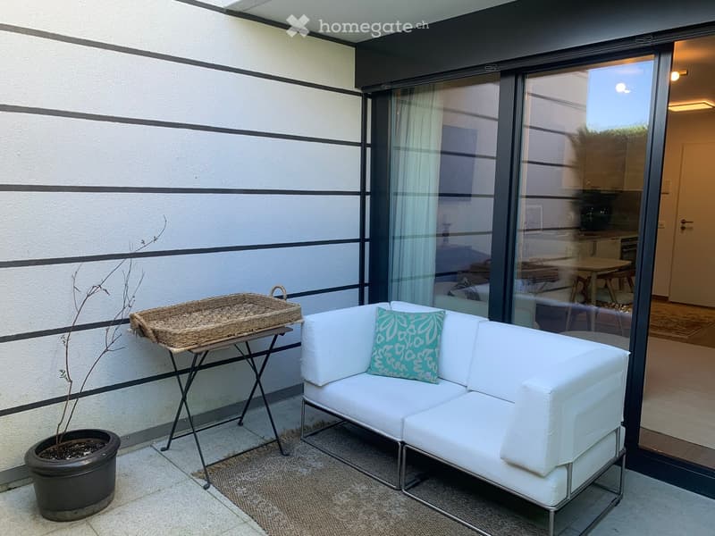 white couch, small table, wicker basket, potted plant, sliding glass door, rug