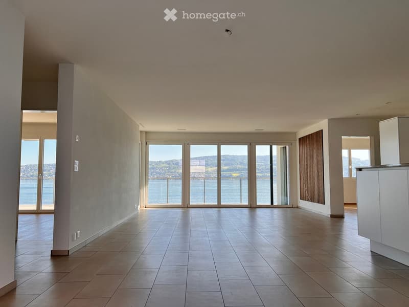 Empty room with tiled floor, large windows, and a view of the water. No furniture or equipment present.