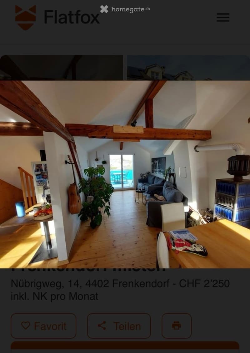 Bright, open-plan living and dining area with wooden floors, exposed wooden beams, large windows leading to a balcony, sofa, dining table, chairs, and a guitar leaning against the wall.
