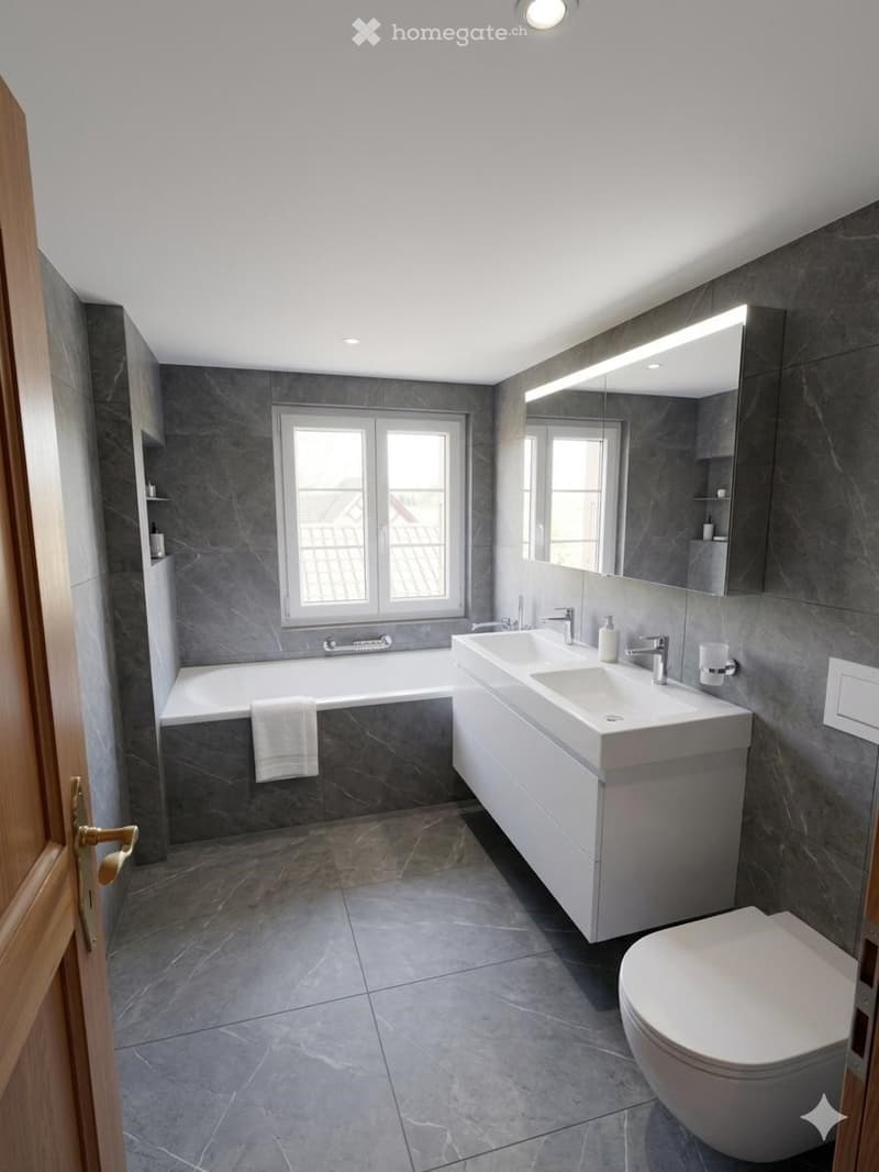Modern bathroom with grey tiles, double sink, bathtub, toilet, large mirror, and a towel on the edge of the tub.