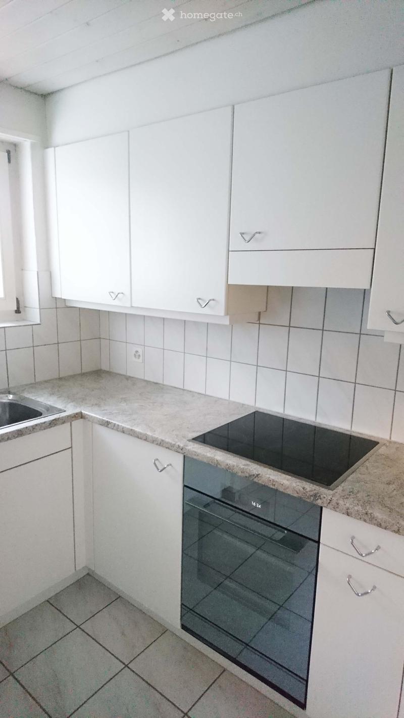 Modern kitchen with white cabinets, granite countertop, electric stove, oven, and sink.