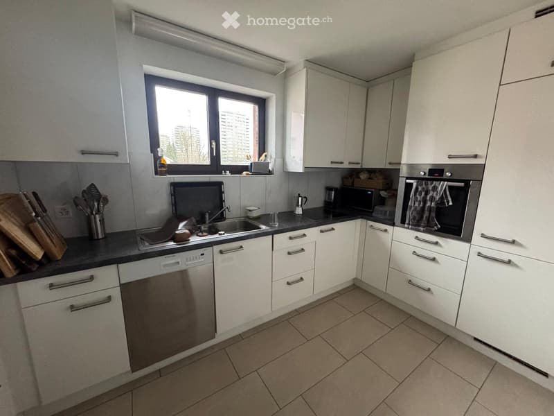 modern kitchen with white cabinets, granite countertops, stainless steel sink, dishwasher, tiled flooring, and a window with a view