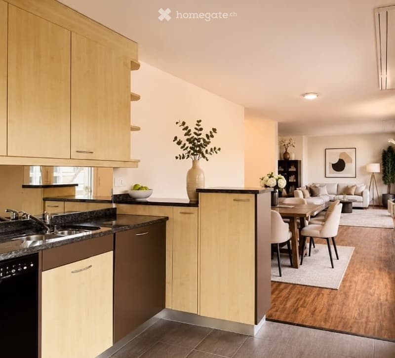 Open-concept kitchen and living area with light wood cabinets, stainless steel appliances, a dining table with chairs, a sofa, and decorative items.