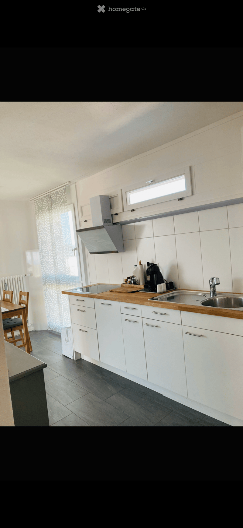 modern kitchen with white cabinets, wooden countertops, stainless steel sink, gas stove, extractor hood, white tiled walls, white ceiling