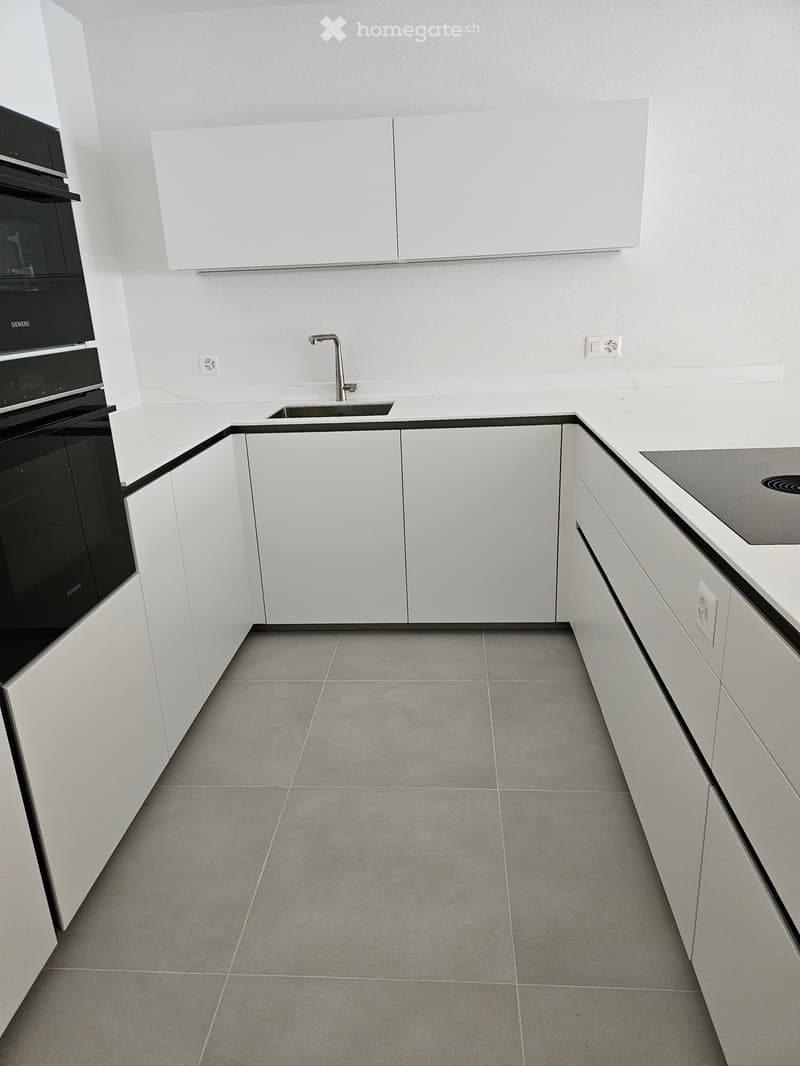 corner room, gray tiles, white cabinets, countertop, sink, electrical outlets