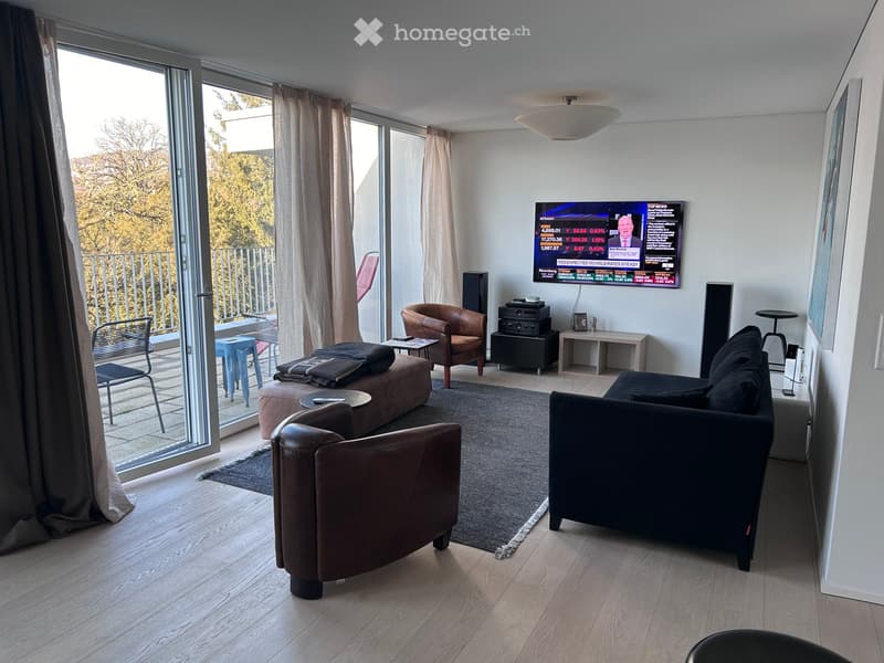 Modern living room with large windows offering a view, featuring a dark leather sofa, brown leather chairs, a coffee table, a small table, a screen, and a lamp.