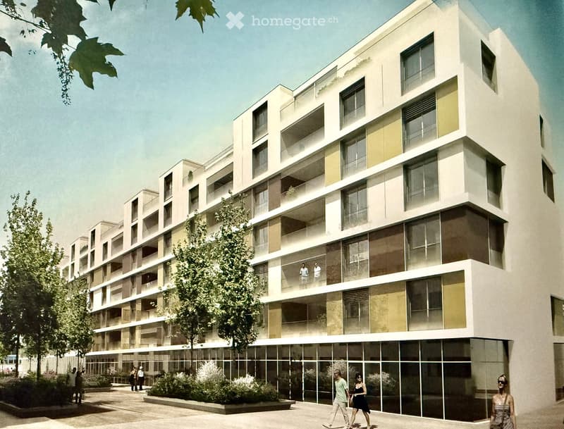 Modern multi-story building with large windows and balconies, surrounded by greenery and a paved area with people walking.